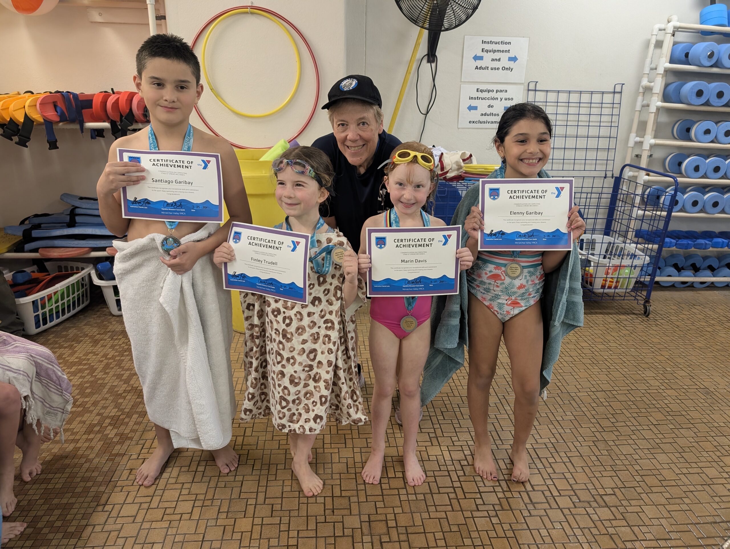 Genie Lutz with young swimmers celebrating their achievements at the local YMCA